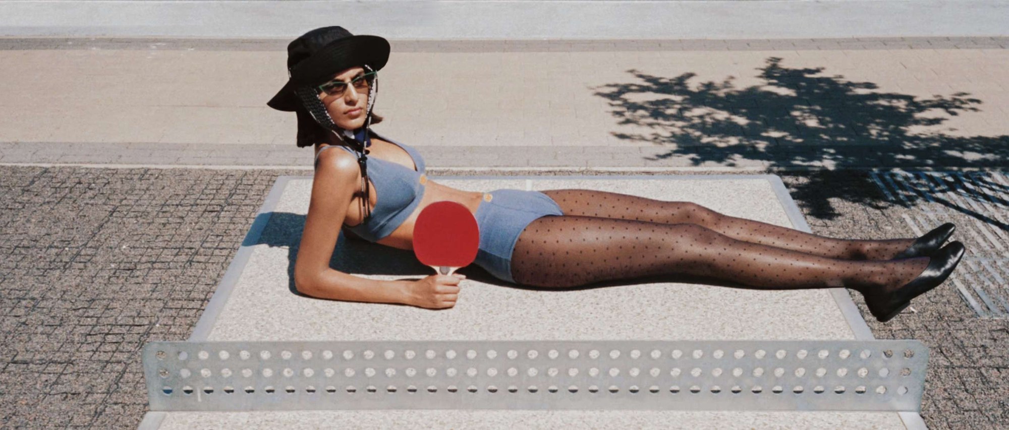 A model in blue lingerie lying on a ping-pong table